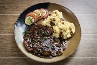 Beef steak meal with mashed potato and gravy sauce on table