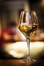 Glass of white wine on bar counter at night