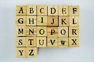 Letters of the latin alphabet on wooden cubes on a neutral background