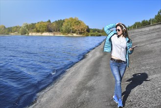 Happy joyful woman listening to music while being outdoor. Music concept