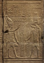 Hieroglyphic carvings of Sebek god and pharaoh on the walls of an ancient egyptian temple