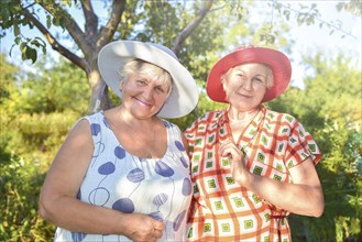 Walk in the garden. Two retired women best friends walk happily in the garden