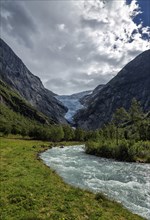 Panoramic view of the Briksdalsbreen glacier with meltwater flow in the foreground