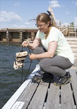 Swedish woman, 44 years old, showing a clay house for settling mussels, Frihamnen, Gothenburg,