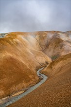 Steaming stream between colourful rhyolite mountains, Hveradalir geothermal area, Kerlingarfjöll,