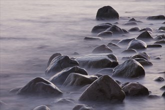 Rocks and pebbles on beach in the surf at low tide, Germany, Europe