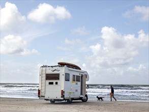 Man with a dog at a mobile home on the beach in Vejers, Denmark, 17.07.2023, Europe