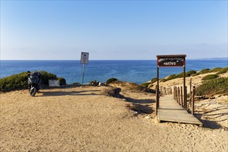 Motorbike on car park with beach access, boardwalk through dune landscape by the sea, Spiaggia di