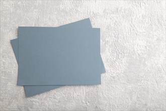 Blue paper business card, mockup on gray concrete background. Blank, flat lay, top view, still