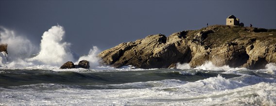 Waves crashing on rocky shore during storm at sea in winter, Côte Sauvage, Quiberon, Brittany,