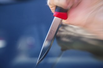 Symbolic image of a knife attack: close-up of a knife in a man's hand