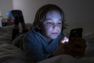 A boy plays computer games on a mobile phone, smartphone