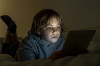 A boy plays computer games on a tablet PC