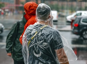 Tourists with rain capes and umbrellas during heavy rainfall, 23.06.2023