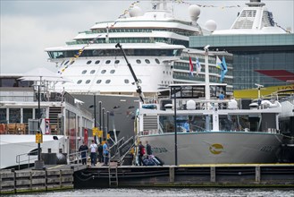 River cruise ships at the quay of the Ij, near the main railway station, passengers' luggage being