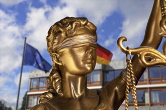 Symbolic image: Close-up of a Justitia, in the background the Federal Constitutional Court in