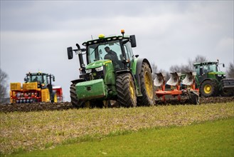 Tractor with a plough preparing the soil of a field for planting, Agriculture, Spring