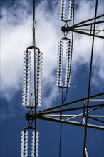 Insulators made of glass on a high-voltage line, they hang on the pylons as a suspension device