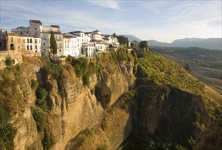 Historic buildings perched on sheer cliff top in Ronda, Spain, Europe