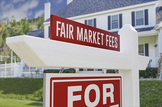 Fair market fees for sale real estate sign in front of new house