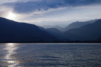 Beautiful Sunset over an Alpine Lake Maggiore with Mountain Range and Sky in Ticino, Switzerland,