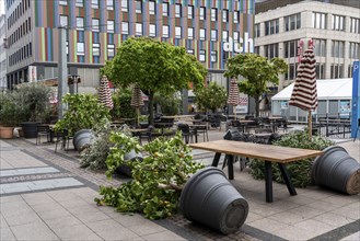 Stacked chairs and tables from various catering establishments, on Kennedyplatz, closed cafes,