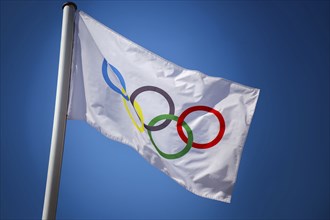 Olympic flag in front of a blue sky