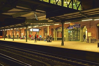 Europe, Germany, Hamburg, Harburg, railway station at night, waiting passengers on the platform,