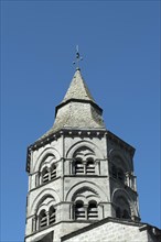 Orcival. Bell tower of the Notre-Dame d'Orcival basilica showcasing Romanesque architecture under a