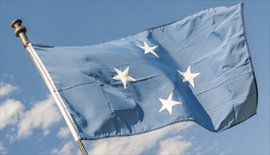 The flag of Micronesia, Pacific Islands, fluttering in the wind, isolated against a blue sky