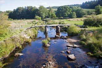 Historic medieval Clapper Bridge at Postbridge, Dartmoor national park, Devon, England crossing the