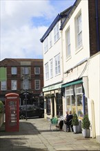 People sitting outside cafe in quiet back street, Devizes, Wiltshire, England, UK