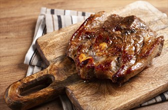 Fried steak, veal neck on the bone, cooking meat, on a wooden board, top view, no people