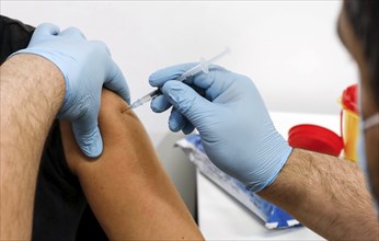 A woman receives a booster vaccination from Moderna against Covid 19 at the Schönefeld vaccination