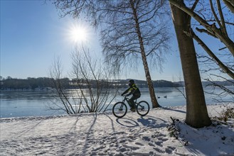 Winter in the Ruhr area, Lake Baldeney, snow-covered, partly frozen lake, walkers on the lakeside