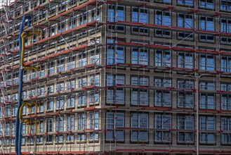 Large construction site, scaffolded shell of an office building complex, air hoses for building