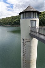 The dam wall of the Urft dam, Grundablassturm, merges into the Rursee, Eifel National Park, North