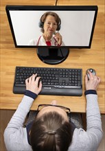 Symbolic image of telemedicine, patient speaking to a doctor in a video conference from home