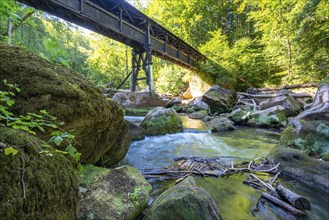 The Irrel Waterfalls, rapids in the lower reaches of the Prüm, covered wooden bridge for hikers,