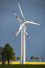 Wind turbines on a rape field, dark rain clouds, in the Rhenish lignite mining area, near