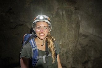 Young woman with helmet and headlamp in a stalactite cave, Terciopelo Cave, Barra Honda National