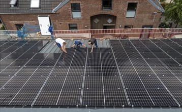 Installation of solar modules on the roof of a barn on a farm, over 210 photovoltaic modules are