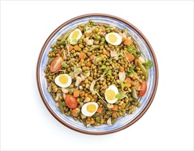 Mung bean porridge with quail eggs, tomatoes and microgreen sprouts isolated on a white background.