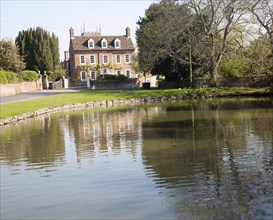 Village duck pond and historic house, in the village of Urchfont, Wiltshire, England, United