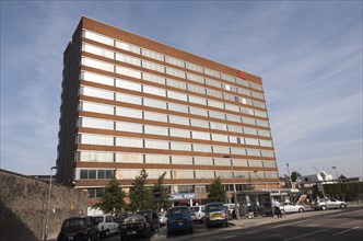 Sunshine lighting up windows of office block above the railway station at Swindon, England, UK