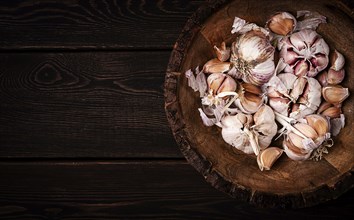 Fresh garlic, in a wooden plate, top view, close-up, no people