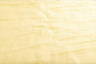 Fragment of smooth yellow linen tissue. Side view, natural textile background and texture