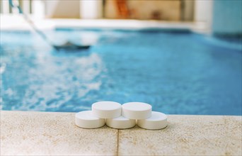 Chlorine tablets for swimming pool cleaning. close up of chlorine tablets on the edge of a swimming