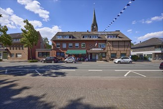 Weseler Strasse with buildings and St. Pankratius church in the Buldern district, Dülmen,