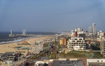 View over the beach of Scheveningen, the pier with Ferris wheel and the skyline of the town, which